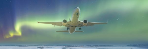 Commercical white airplane fly up over take-off runway the (ice) snow-covered airport with aurora borealis - Norway